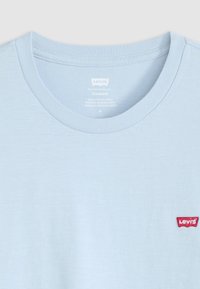 Lichtblauw katoenen t-shirt met een ronde halslijn en korte mouwen. Heeft een rood Levi's logo patch aan de linkerkant.