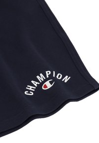 Navy blue Champion shorts made of soft cotton blend fabric, featuring white embroidered logo and red and white accent in the logo design.