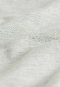 Világosszürke szövet, puha, sima textúrával és finom márványos mintával, lágy redőkben bemutatva. Ideális alkalmi ruházati felhasználásra.