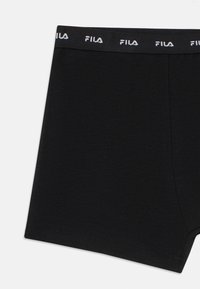 Boxer ajustados negros con una cintura elástica negra que presenta logotipos repetidos de FILA en blanco, mostrados sobre un fondo blanco.