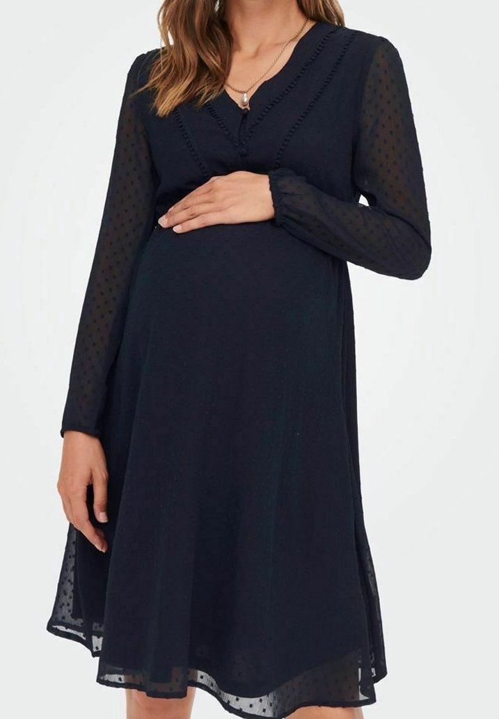 Robe de maternité bleu marine avec de longues manches transparentes à pois, col en V et garniture décorative, silhouette évasée, longueur au genou.