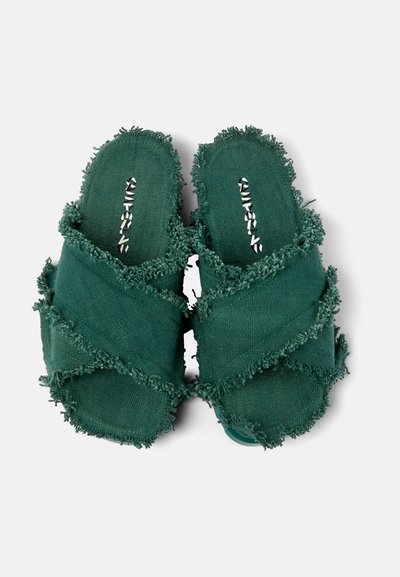 Gröna tygslipade sandaler med fransiga kanter, öppen tådesign och korskorsade remmar. Mjuk textur och avslappnad look.