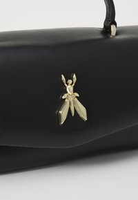 Borsa in pelle nera con un'applicazione a forma di insetto dorato, superficie liscia e un design strutturato con un'unica maniglia.