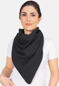 Écharpe noire en forme triangulaire faite d'un tissu texturé, présentant un motif froissé, drapée autour des épaules, avec une finition douce.