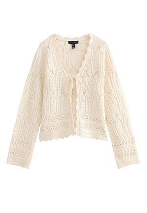 Cardigan de punto color crema con mangas largas, bordes con ondas, patrones intrincados de encaje y cierre frontal con lazo.