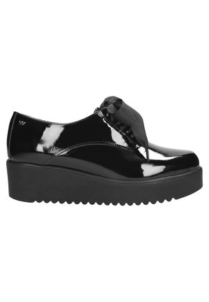 Black patent leather platform shoes with a rounded toe and black ribbon laces. Features a textured black sole and subtle branding on the side.