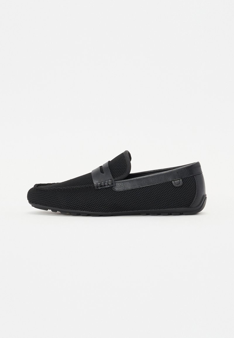 Des mocassins noirs en matériau en maille avec des accents en cuir. Dotés d'une surface texturée et d'un détail de sangle lisse sur le cou-de-pied.