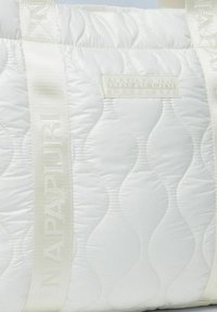 Borsa a spalla bianca trapuntata con motivi ondulati orizzontali, dotata di manici avorio stampati con "NAPAPIJRI" e una piccola etichetta con logo.