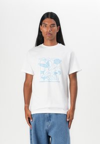 Tricou alb din bumbac cu un design abstract albastru și textul "LIBERTATE DIN HAOS." Mâneci scurte, gât rotund, croiala relaxată.