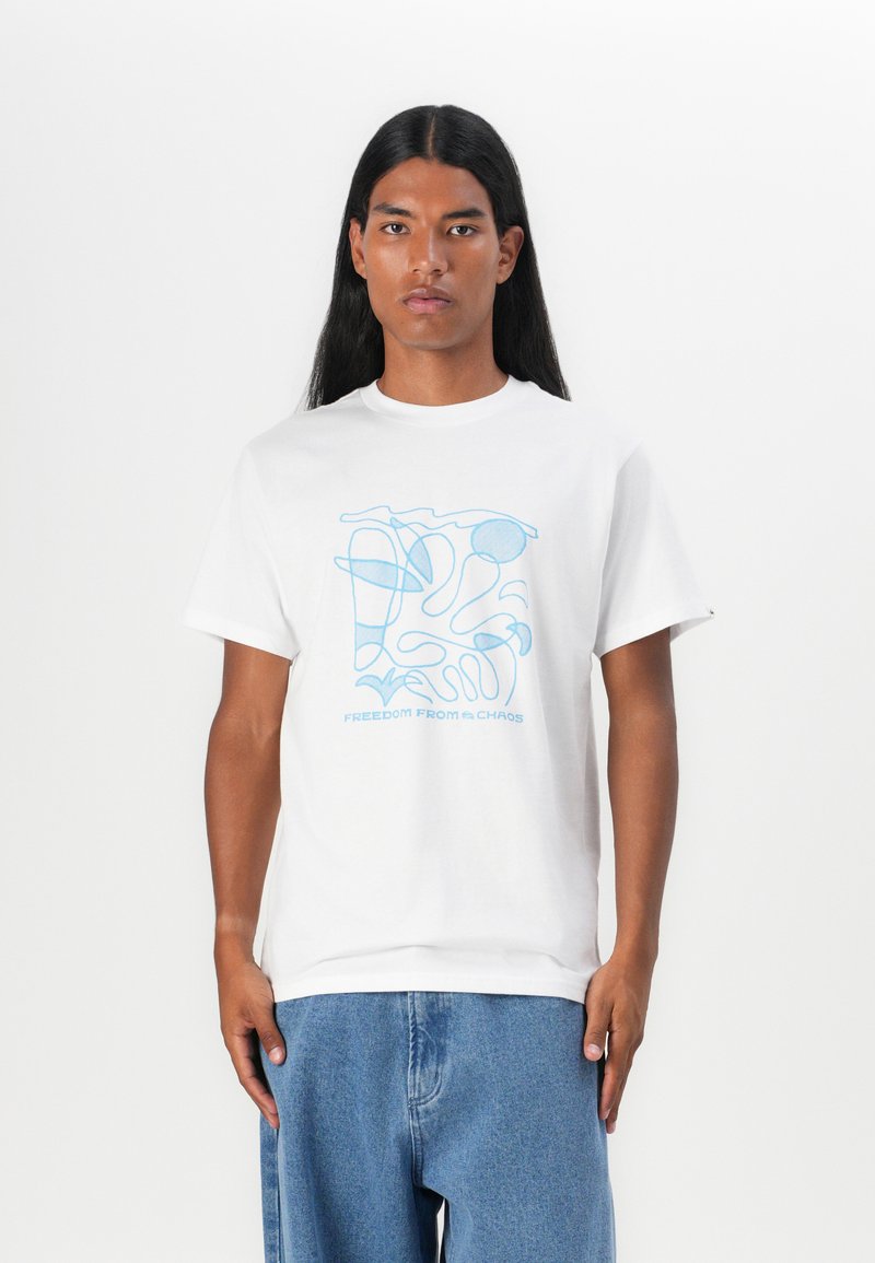 Tricou alb din bumbac cu un design abstract albastru și textul "LIBERTATE DIN HAOS." Mâneci scurte, gât rotund, croiala relaxată.