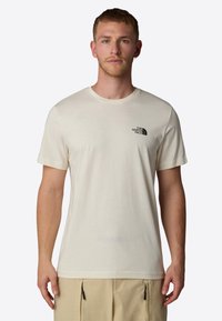 Kortærmet, crèmefarvet t-shirt lavet af blødt stof. Har et lille sort logo på venstre bryst. Enkel, klassisk crew neck design.