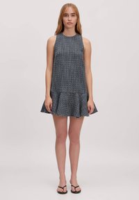 Navy- und weiß gemustertes ärmelloses Kleid mit ausgestelltem Saum, aus strukturiertem Stoff gefertigt. Einfaches Design ohne sichtbare Verzierungen.
