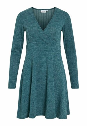 Teal long-sleeve dress with a v-neck, featuring textured fabric and a fitted bodice that flows into a flared skirt. Geometric pattern throughout.