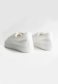 Sneaker bianche in pelle con superficie testurizzata, punta tonda e design con lacci; suola in gomma con un sottile motivo di battistrada.