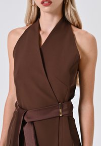 Braunes Neckholder-Kleid mit tailliertem Oberteil, einem Satin-Gürtel mit goldfarbenen Hardware-Details und glattem, leichtem Stoff.