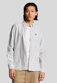 Camicia a maniche lunghe a righe in cotone bianco e blu con colletto a punta e logo ricamato giallo sulla tasca del petto.