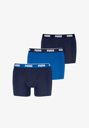 Trzy pary bokserek: jedna ciemna granatowa, jedna intensywnie niebieska i jedna średnia granatowa. Wszystkie mają białą gumkę z logo PUMA. Gładka tekstura materiału.
