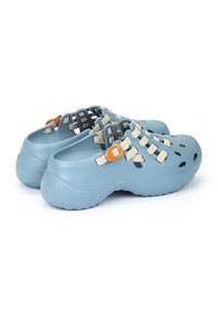Zuecos de color azul claro hechos de plástico con una superficie texturizada, que cuentan con orificios de ventilación recortados, correas beige y detalles en hardware naranja.