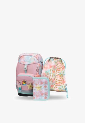 Rosa und pastellfarbener Rucksack mit tropischem Motiv, passende Kordeltasche mit dem Schriftzug „Dream“ und ein Blumenfedermäppchen auf weißem Hintergrund arrangiert.