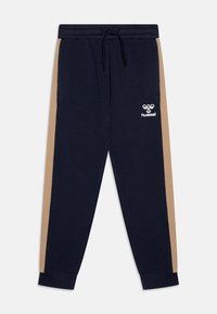 Mörkblå sweatpants med beige sidostripes, dragsko i midjan, muddade anklar och vit Hummel-logga på höger lår.