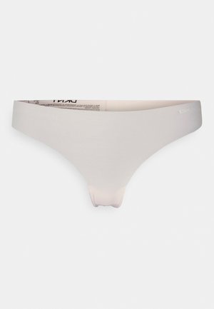 Lichtbeige thong van glad, rekbaar materiaal. Voorzien van een brede tailleband met logo-detail, minimale naadlijnen en een naadloos ontwerp.