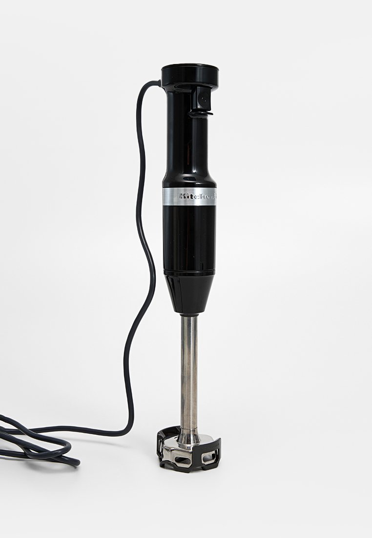 Czarny blender ręczny ze stalową głowicą do blendowania, posiadający teksturowany plastikowy uchwyt oraz elastyczny przewód zasilający. Srebrny akcent marki.