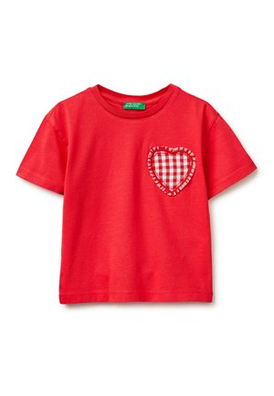 T-shirt enfant rouge à manches courtes avec un col rond et un patch en forme de cœur à carreaux sur le côté gauche de la poitrine.