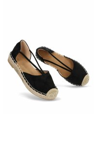 Espadrilles de ante negro con una tapa de punta de fibra natural tejida, lados expuestos y costuras blancas contrastantes a lo largo de la suela.