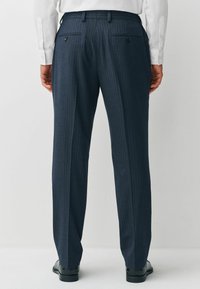 Die marineblauen Nadelstreifen-Hosen zeichnen sich durch einen maßgeschneiderten Schnitt, glattes Material, zwei Gesäßtaschen mit Knopfverschluss und ein gerades Bein-Design aus.