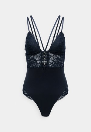 Marineblå blonde bodysuit med justerbare stropper, der har en dyb udskæring, blonde detaljer og en trykknaplukning nederst.