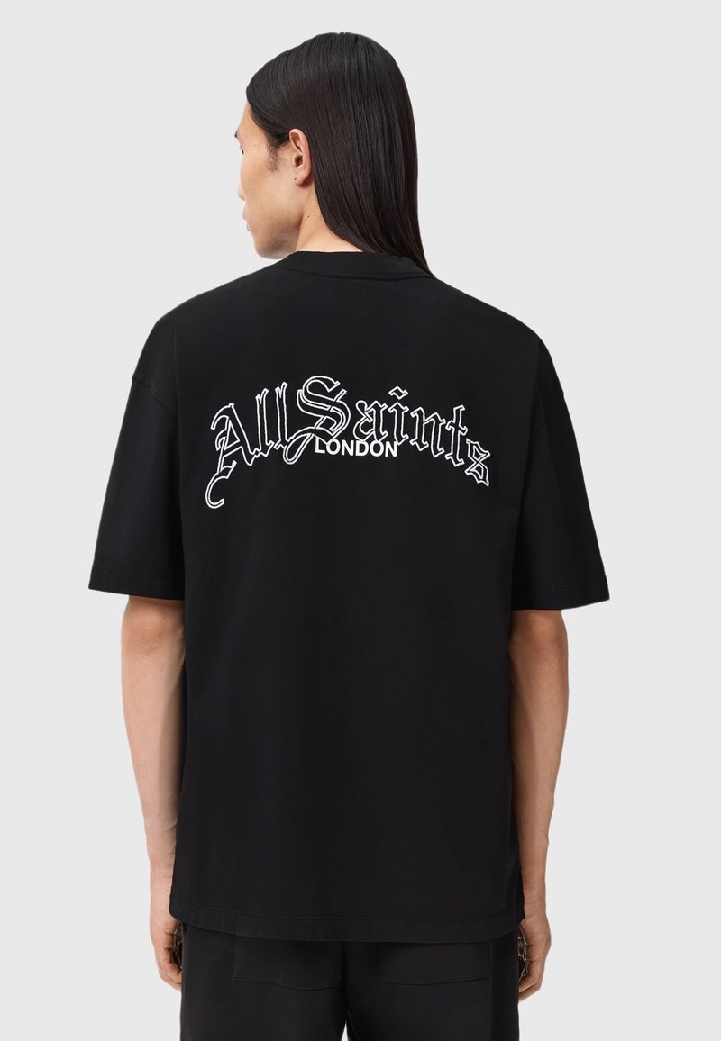 Sort bomulds-T-shirt med rund hals og afslappet pasform. Har hvidt scriptlogo "All Saints London" broderet på ryggen.