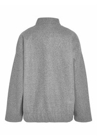 Šedá, převeliká fleecová bunda s vysokým límcem, spadenými rameny a zaobleným spodním okrajem. Má měkkou, kartáčovanou strukturu.