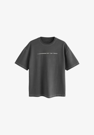 Tricou gri închis cu o croială lejeră, mâneci scurte și text alb "OFF THE TRACK" suprapus peste un model de linii orizontale. Detaliu de cusătură albă.