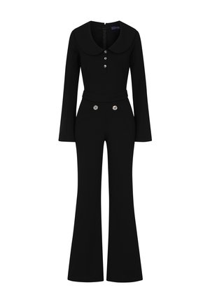 Sort jumpsuit med krave, lange ærmer, knaplukning og flagrende bukser. Har dekorative knapper ved taljen.