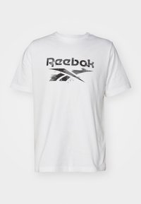 Bílý bavlněný tričko s krátkým rukávem, na kterém je černý grafický logo Reebok přes hrudník. Hladká textura, klasický kulatý výstřih.
