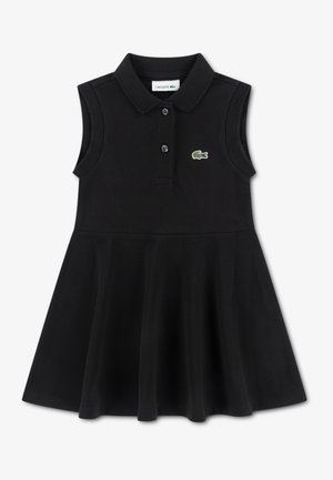 Robe polo noire sans manches en tissu doux. Caractérisée par un col classique, une patte de boutonnage et le logo crocodile Lacoste vert. Jupe évasée.