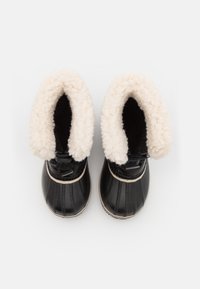 Svarte vanntette støvler med hvit fleece-fôr og strukturert svart overdel. Har snøring og gummisåle.