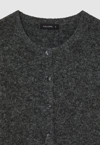 Cardigan gris foncé en tissu texturé, avec un col rond et cinq boutons noirs sur le devant. L'étiquette indique "CALLIOPE."