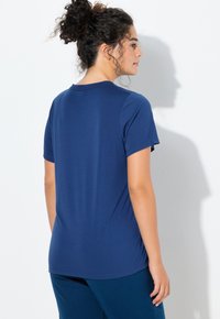 Tmavě modré tričko s krátkými rukávy z měkké látky, s klasickým kulatým výstřihem a volným střihem, s hladkou texturou.