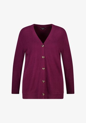 Bordeaux cardigan met een v-hals en lange mouwen. Kenmerkt zich door hartvormige gouden knopen aan de voorkant en een zachte, gehaakte stof.