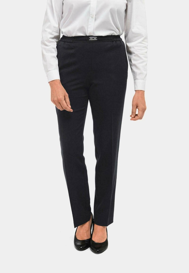 Marineblauwe pantalon met een rechte pasvorm, gemaakt van zachte stof, met een elastische tailleband en een slanke uitstraling, gecombineerd met zwarte schoenen.
