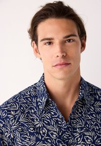 Tumesinine särk valge lillemustriga. Loev krae ja nööbid, valmistatud kergest, tekstuuriga kangast.