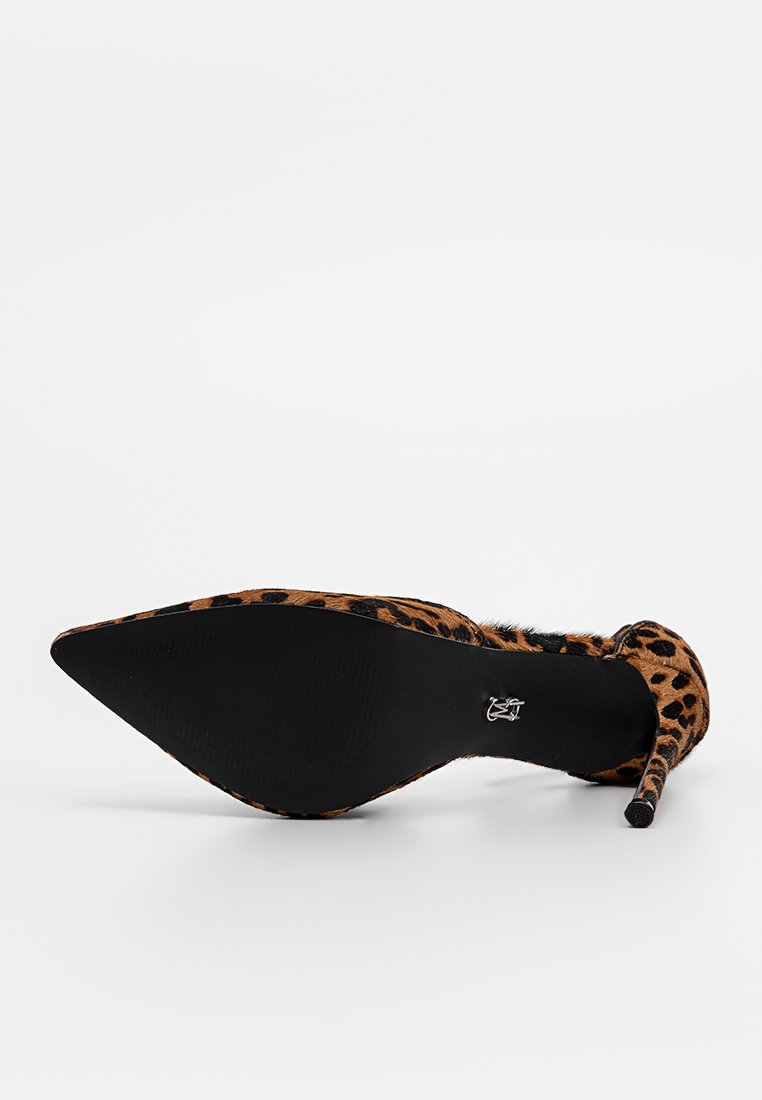 Scarpa con tacco alto in stampa leopardata, punta affusolata, texture pelosa e tacco stiletto sottile. Suola nera piatta con dettagli del logo.