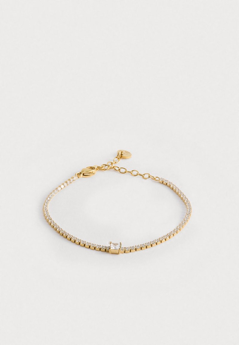 Aranyozott karkötő, melyet kis átlátszó kristályok díszítenek. Állítható lánc négyzet alakú középponttal, sima textúrával és finom tervezéssel.