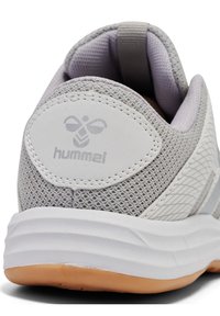 Baskets de sport gris clair avec tige en mesh et semelle en caoutchouc. Comprend un col rembourré, un détail de logo et des accents texturés sur les côtés.