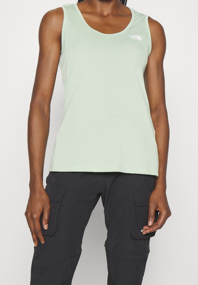 Ljusgrön ärmlös tanktopp i mjukt tyg med rundad halsringning och logodetalj på bröstet. Enkel, figurnära design.