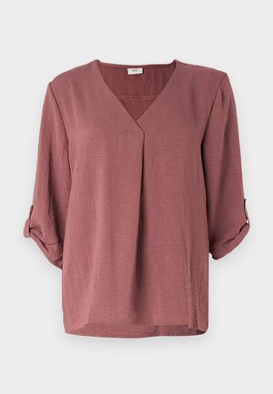 V-hals, losse shirt gemaakt van een gestructureerde stof in een verzacht rozenkleur, met opgerolde mouwen, zonder zichtbare patronen of versieringen.
