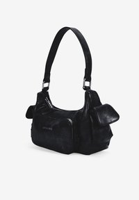 Bolso de mano de cuero negro con un diseño estructurado, que presenta una correa desmontable, compartimentos con cremallera y acentos de solapa sobredimensionados.