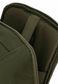 Custodia per laptop verde imbottita con un esterno morbido e resistente all'acqua, cuciture robuste e una chiusura con zip dotata di un tirante in tessuto.