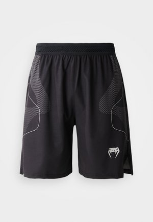 Svarte treningshorts med teksturerte sidepaneler, elastisk midje og en hvit fanget slange-logo nederst til venstre på benet.